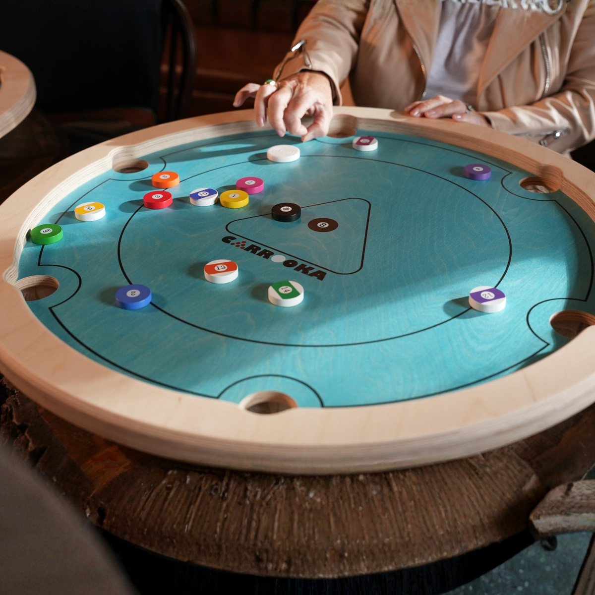 Close-up van het Carrooka Pool 8 Blue bord tijdens het spel, met poolfiches verspreid over het blauwe speelveld