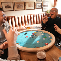 Vrienden lachen tijdens een potje Carrooka Pool 8 Blue aan een tafel in de pub