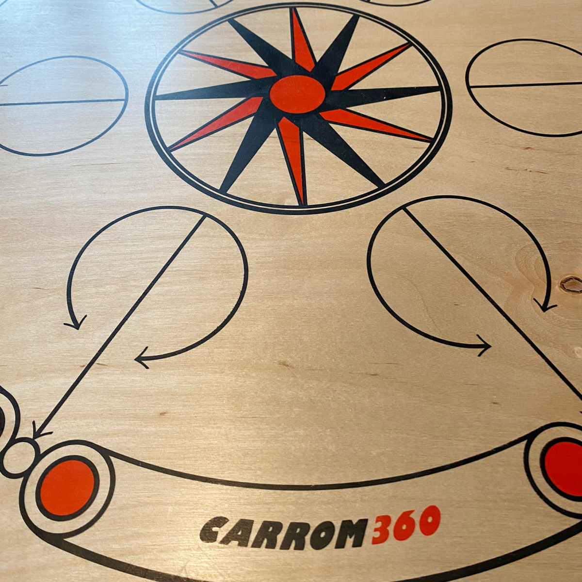 Close-up van het zeefdrukdesign van het Carrooka Carrom360 bord met ster en logo