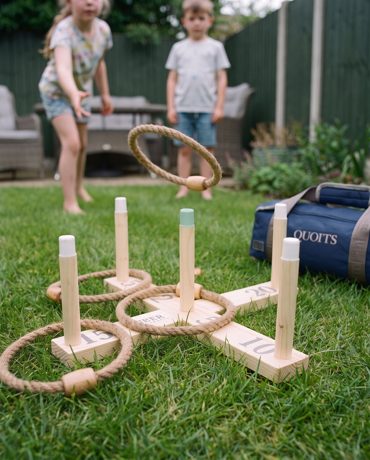 Speler gooit een natuurvezel touwring naar de houten pinnen van Mini Ringwerpen